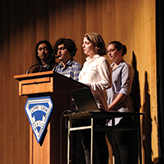 A group of students speaking at a podium